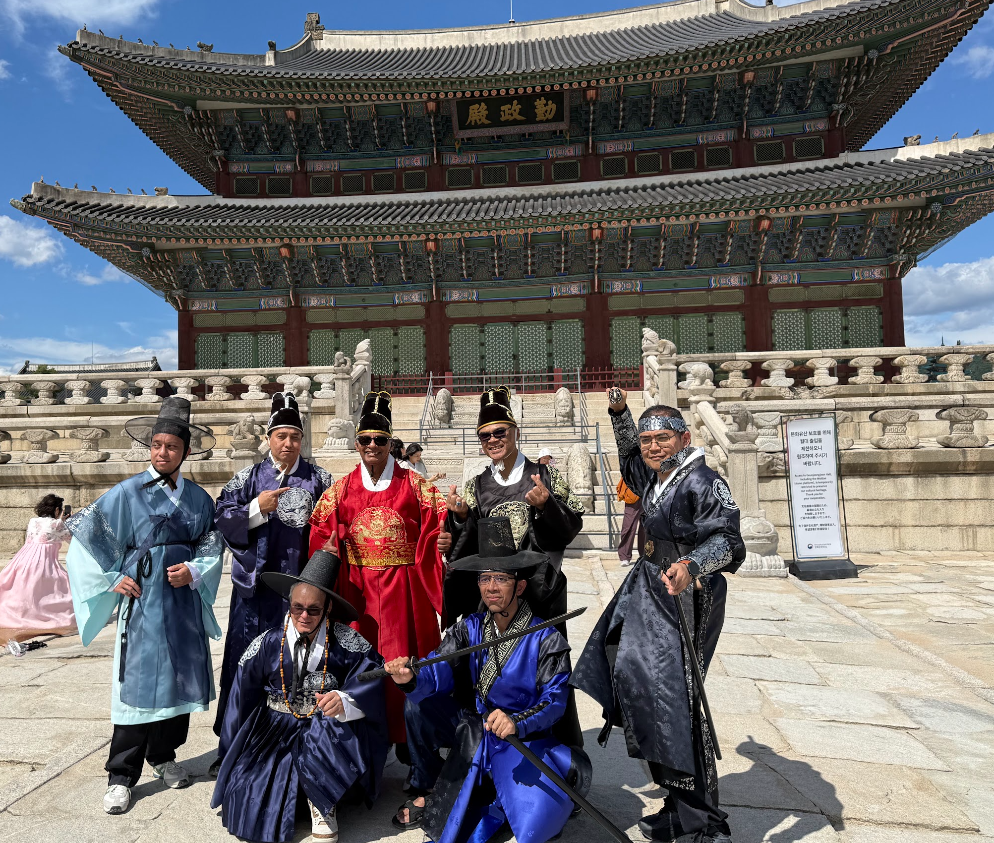 Viajeros vestidos con hanbok frente a un palacio en Seúl